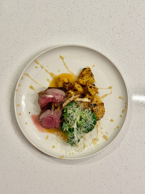 Herb-crusted lamb with roast potatoes & parmesan broccoli